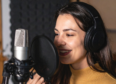 Lady making a voice over for adverts with a professional microphone